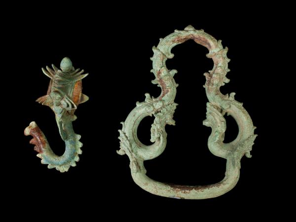 Image of two jewelry items, a hook and a ring against a black backdrop